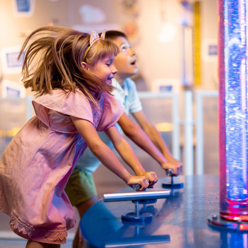 A girl in a pink dress enjoying a museum activity, featured in a guide for family-friendly events in Dallas this August.